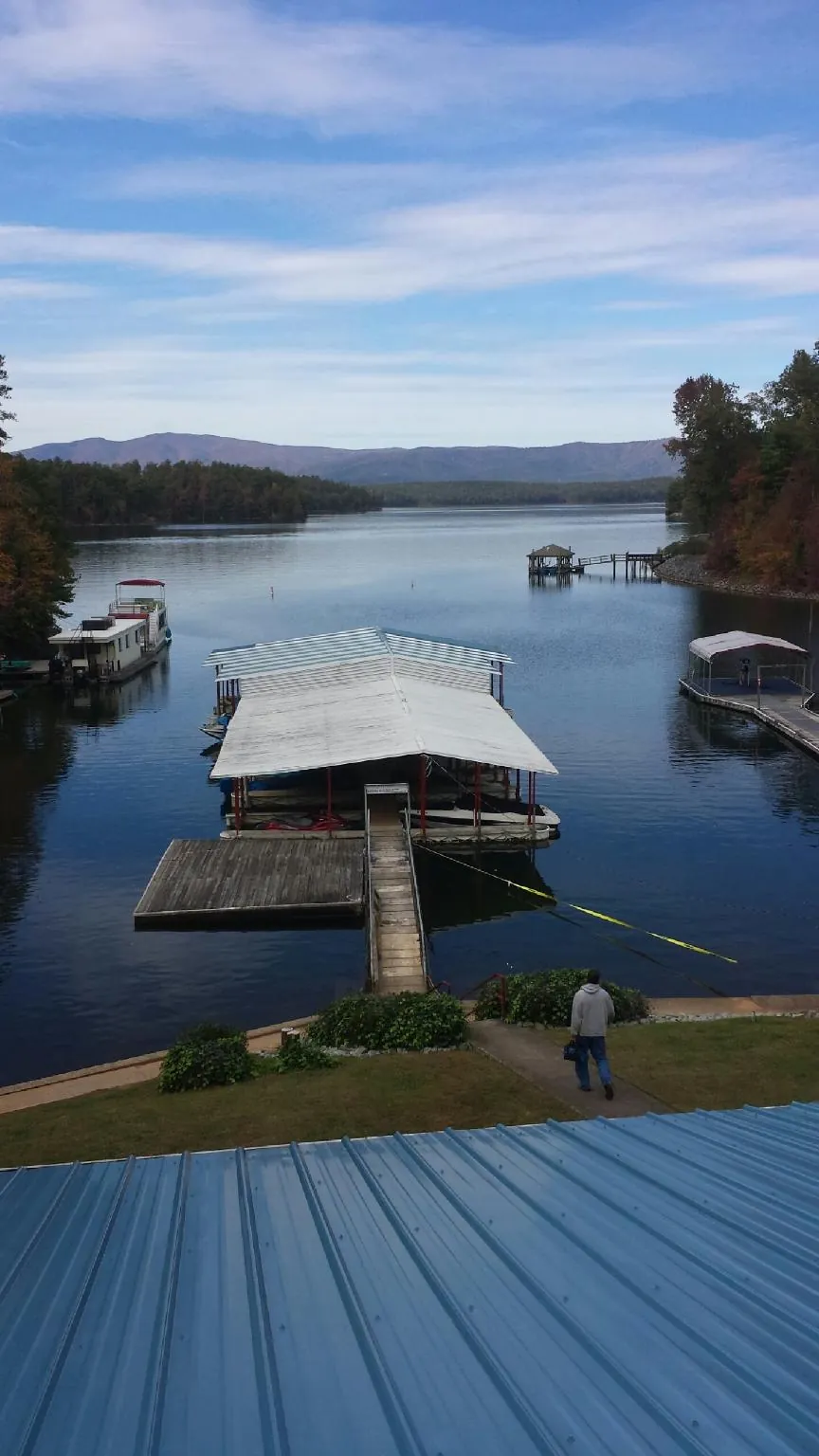 View across a lake from a newly installed blue metal roof in Beecher
