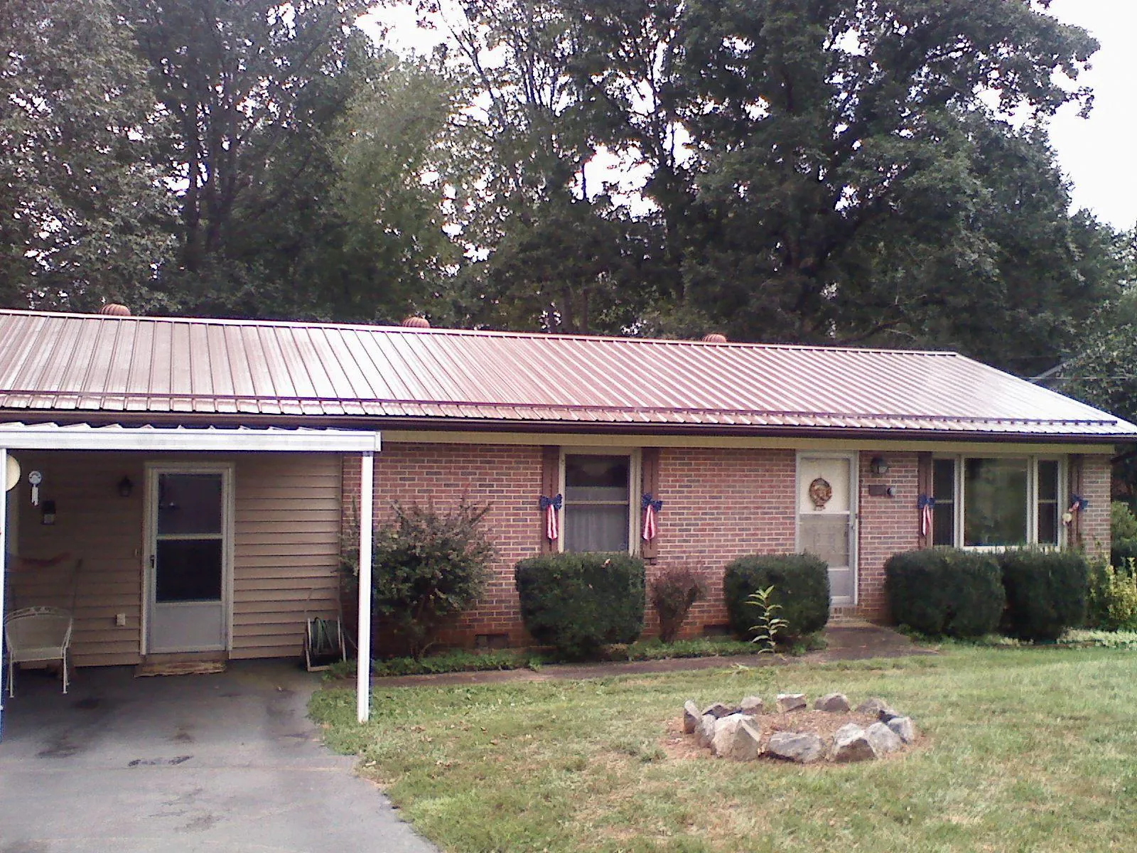 Bronze metal roof and carport on a brick ranch home — Roof Repair work by our crew in Beecher